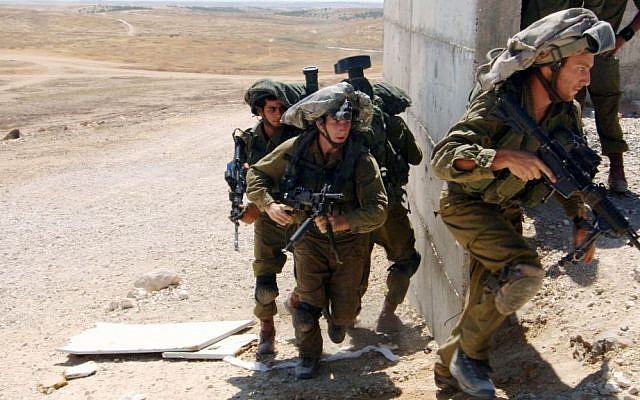 Israeli soldiers from the Paratroopers Brigade take part in a training exercise where they practice door-to-door combat in inhabited areas in Tze'elim, southern Israel, Thursday, July 10, 2014. (Flash90)