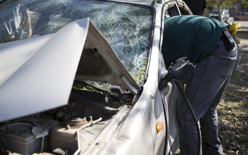 A man takes his belongings out of his car, which sustained severe damaged after a rocket landed on in near Sderot, southern Israel, on Thursday July 10, 2014, the third day of Operation Protective Edge. (photo credit: Hadas Parush/Flash90)