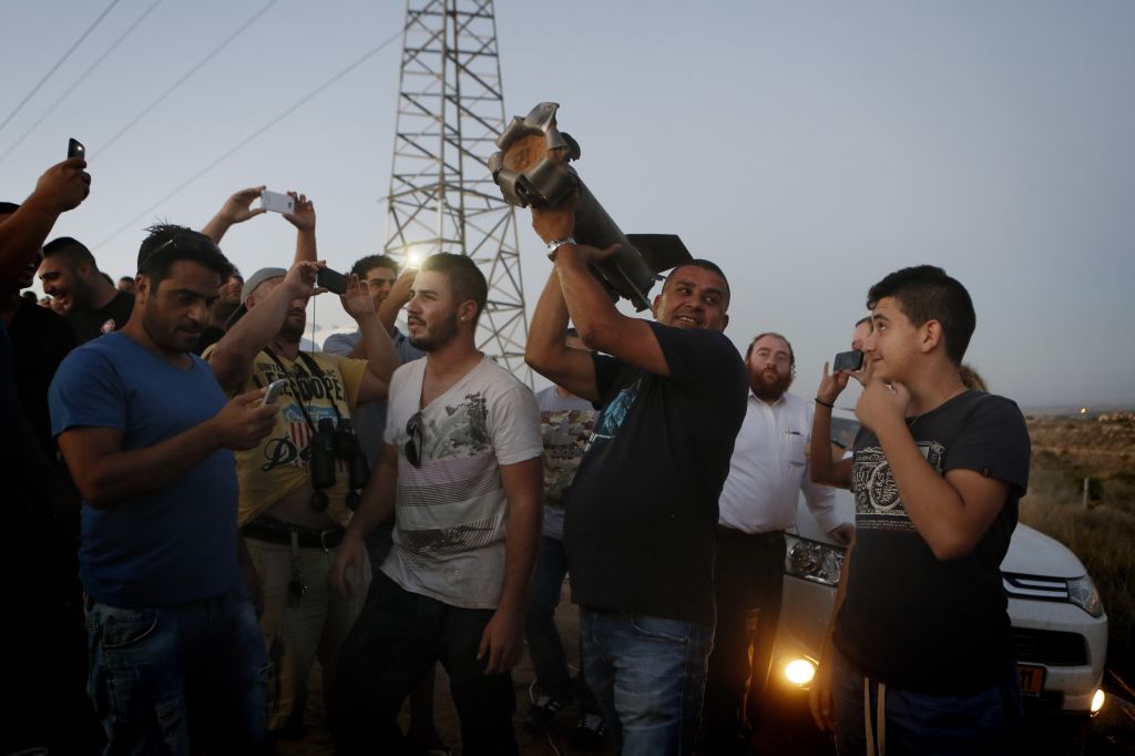 Residents of Sderot looking at a piece of a rocket that fell in an open field (photo credit: Miriam Alster/Flash 90)