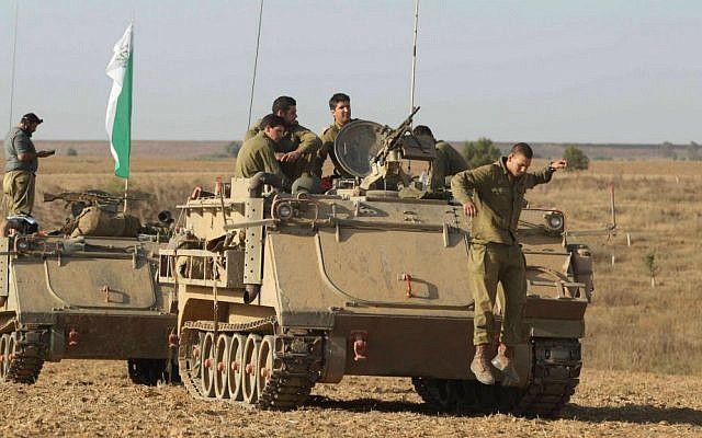 IDF soldiers seen near armored personnel carriers (APCs) by the southern Israeli border with Gaza, on the eighth day of Operation Protective Edge, July 15, 2014. (photo credit: Yossi Aloni/Flash90)
