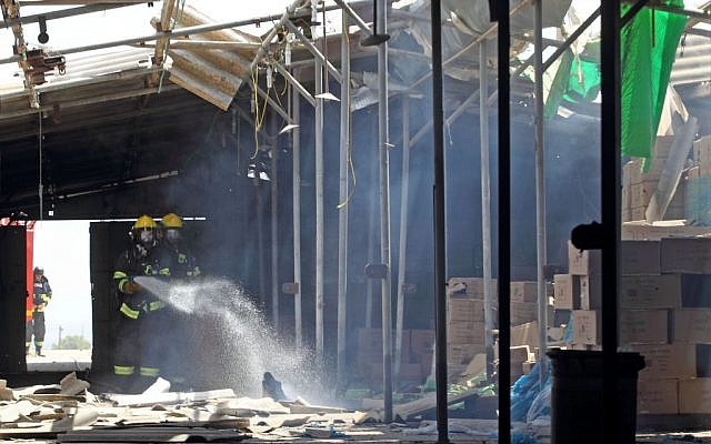 Firefighters extinguish a blaze caused when a rocket lobbed from Gaza struck kibbutz Nir Am in southern Israel on Tuesday, July 15, 2014 (photo credit: Yossi Aloni/FLASH90)