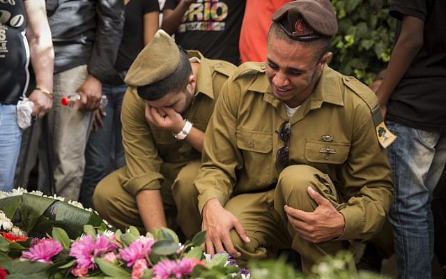 Fellow soldiers seen mourning over the fresh grave of Golani soldier, Moshe Malko, at the Har Herzl Military Cemetery in Jerusalem, on July 21, 2014. Staff Sgt. Moshe Malko, 20, from Jerusalem, was killed yesterday before dawn during combat in the Gaza Strip. (photo credit: Hadas Parush/Flash90)