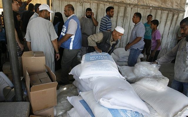 Palestinians receive aid at a United Nations distribution center (UNRWA) in the Rafah refugee camp, southern Gaza Strip on July 31, 2014 (photo credit: Abed Rahim Khatib/Flash90)