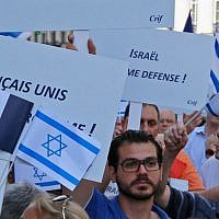Demonstrators hold Israeli and French flags and placards reading 'French and All United Against Terrorism' during a gathering in front of the Israeli Embassy in Paris, France, Thursday, July 31, 2014. (AP Photo/Francois Mori )
