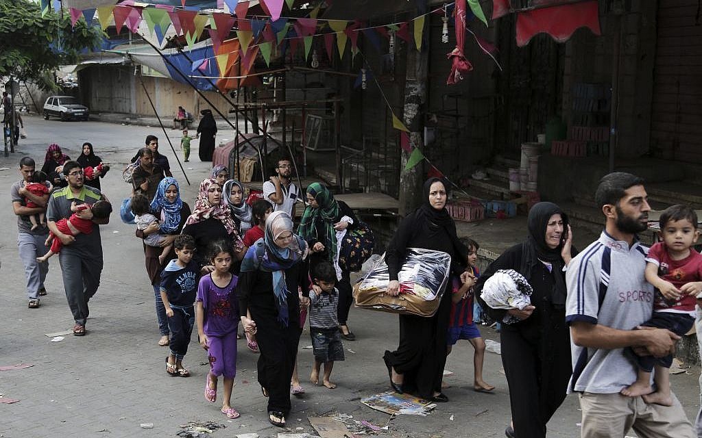 Palestinian families who fled their homes from Shejaiya neighborhood, arrive to Gaza City, northern Gaza Strip on Sunday, July 20, 2014. (photo credit: AFP/Adel Hana)