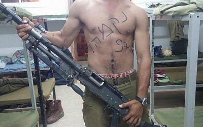 A soldier poses with a gun. The word 'revenge' is written across his chest. (photo credit: The People of Israel Demand Vengeance/Facebook)
