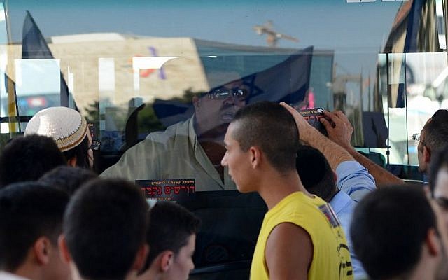 Right-wing protesters bang on a bus and put stickers that call for revenge in front of its Arab bus driver during a large protest in central Jerusalem, on July 1, 2014, in response to the kidnapping and killing of three Jewish teens (photo credit: Mendy Hechtman/Flash90)