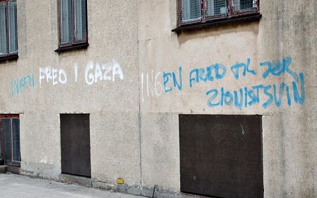 Anti-Jewish graffiti is seen on a wall of a Jewish school on August 22, 2014 in Copenhagen. The text on the wall says: 'Peace in Gaza and no peace to you Zionist pigs'. (Photo credit: AFP / Scanpix DENMARK / Erik Refner)