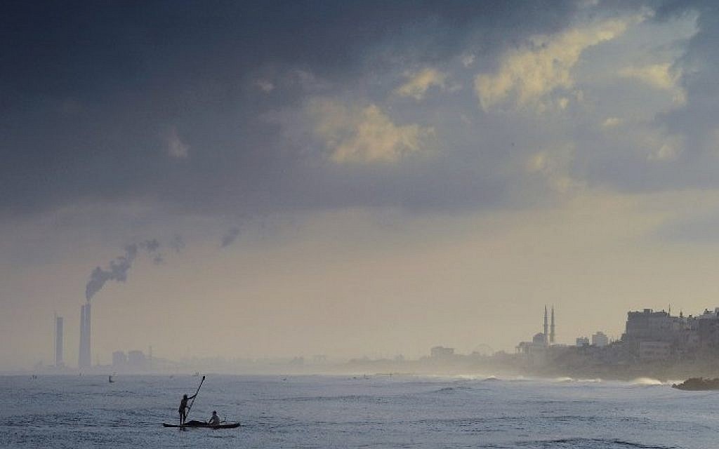 Illustrative photo of Palestinian fishermen paddling their small boat a few hundred meters off the beach of Gaza City while casting their nets in search of small fish on August 10, 2014. (AFP/Roberto Schmidt)