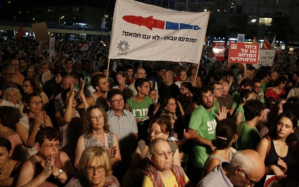 Demonstrators hold a placard reading in Hebrew: "Agreement with Abbas not with Hamas" as thousands of Israelis protest during a left-wing peace rally in the coastal city of Tel Aviv calling for the Israeli government to negotiate with the Palestinian Authority on August 16, 2014. (photo credit:AFP/GALI TIBBON)