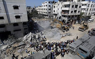 A digger removes the cement and debris on August 20, 2014, of a home destroyed the night before in an Israeli airstrike on Gaza City's Sheikh Radwan neighborhood, which killed the wife and two children of elusive Hamas military chief Muhammad Deif, the Islamist group said. (photo credit: AFP/Mohammed Abed)