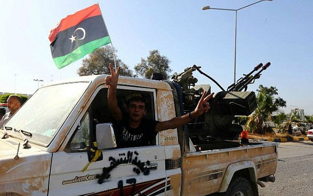 An Islamist fighter from the Fajr Libya (Libyan Dawn) coalition flashes the V sign for victory at the entrance of Tripoli international airport on August 24, 2014 (photo credit: AFP/MAHMUD TURKIA)