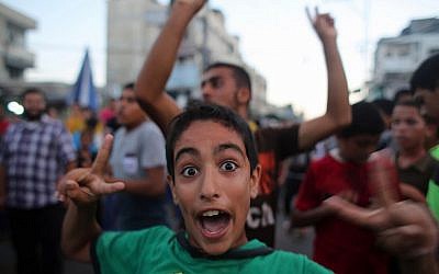 A Palestinian boy flashes the sign of victory as people gather in the streets of Rafah to celebrate after a deal was reached between Hamas and Israel over a long-term end to seven weeks of fighting, Tuesday, August 26, 2014 (photo credit: AFP/SAID KHATIB)