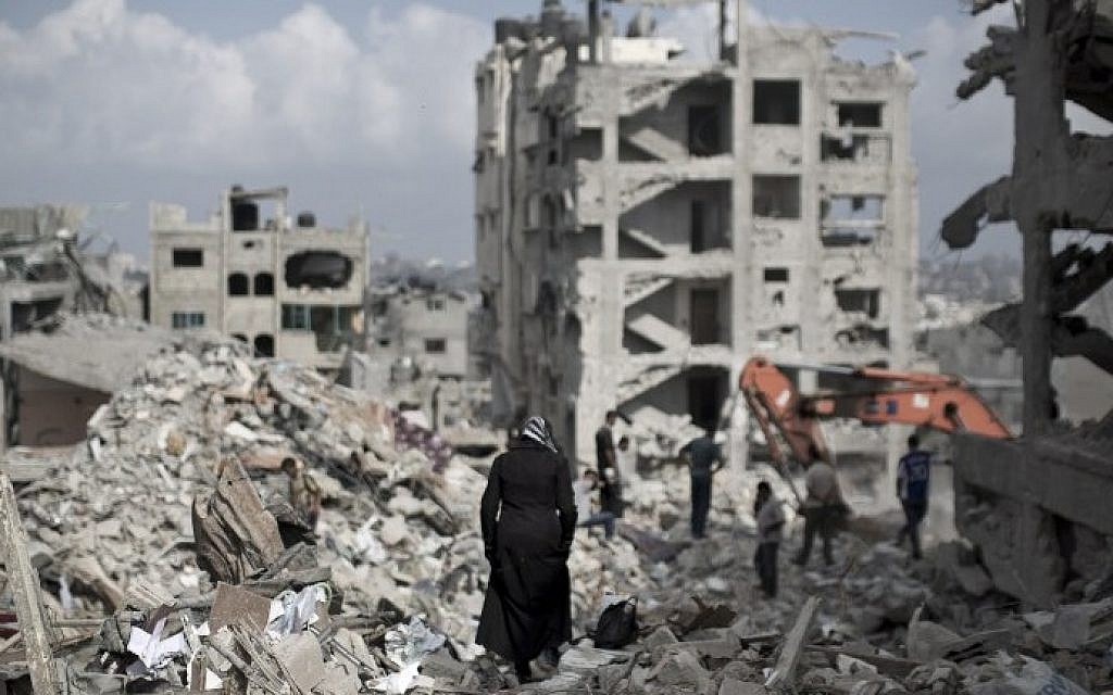 A Palestinian woman walks through the rubble of destroyed buildings in part of Gaza City's al-Tufah neighbourhood as the fragile ceasefire in the Gaza Strip enters a second day on Wednesday, August 6, 2014. (photo credit: Mahmud Hams/AFP)