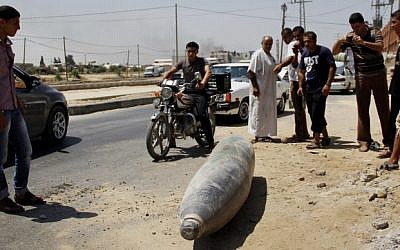 Palestinians look at an unexploded Israeli missile, which witnesses said was fired by an Israeli aircraft on a street in Deir El-Balah in the central Gaza Strip on August 01, 2014. (Photo credit: Mostafa Ashqar/Flash90)