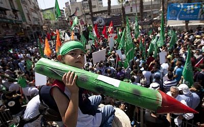 A Palestinian boy holds a model rocket at a Hamas demonstration in the West Bank city of Ramallah, Friday, Aug. 22, 2014. (photo credit: AP Photo/Majdi Mohammed)