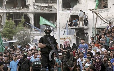 Palestinian gunmen from the military wing of Hamas during what they termed a 'victory rally' amid the debris of destroyed houses in Shejaiya, a Hamas stronghold of Gaza City, Wednesday, August 27, 2014. (photo credit: AP/Adel Hana)
