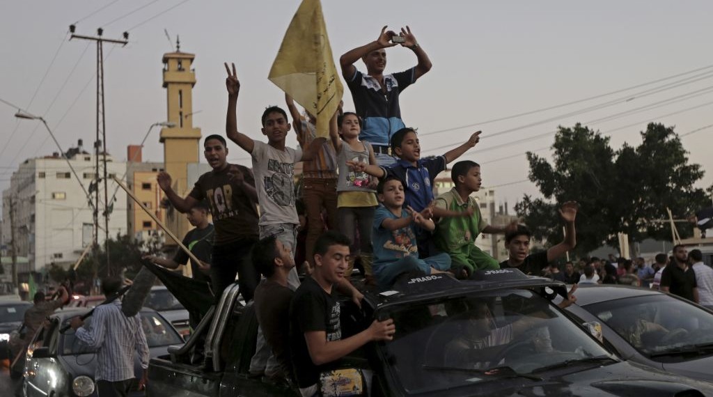 Gazans celebrate the Israel-Hamas ceasefire, in the northern Gaza Strip, Tuesday, Aug. 26, 2014.  (photo credit: AP Photo/Adel Hana)