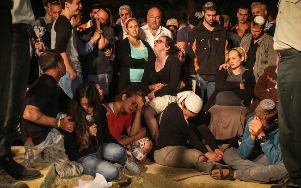 Relatives and friends of Major Benaya Sarel who was was killed in combat on Friday in the Gaza Strip seen mourning over his grave during a funeral at the old Jewish cemetery in Hebron, August 3, 2014 (photo credit: Flash90)