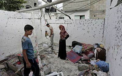 File: Palestinians inspect the damage to a house in the Jebaliya refugee camp that was hit by an Israeli strike in the northern Gaza Strip, Sunday, Aug. 3, 2014. (photo credit: AP/Lefteris Pitarakis) 