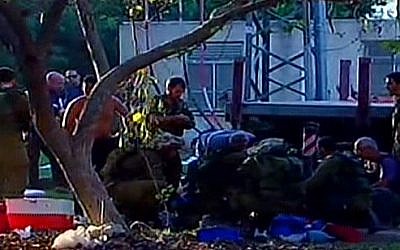 First responders and IDF soldiers at the scene of a mortar barrage on Kibbutz Nirim in the Eshkol region. (screen capture: Channel 2)