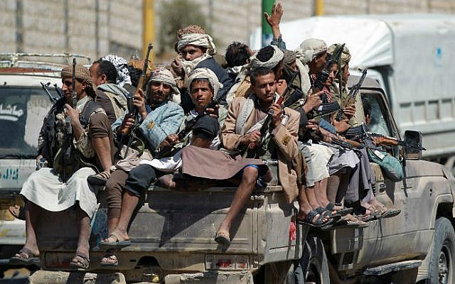 Armed Yemeni Shiite Houthi anti-government rebels sit in the back of a pick-up truck as they drive near the state television compound in the capital of Sana'a, September 21, 2014. (photo credit: AFP/Mohammed Huwais)