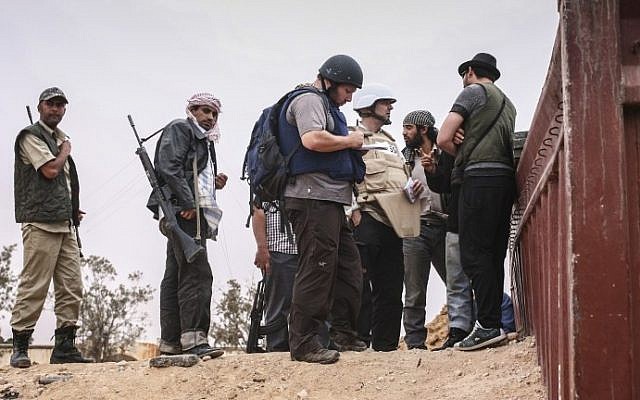 File photo dated June 02, 2011 courtesy Etienne de Malglaive shows American journalist Steven Sotloff (center with dark helmet) talking to Libyan rebels (photo via AFP)