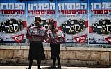 Orthodox schoolgirls looking at posters in Beit Shemesh in June 2014. (Yaakov Lederman/Flash90)