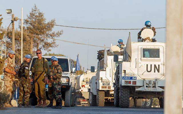 Illustrative: Members of the United Nations Disengagement Observer Force (UNDOF) are seen near an IDF soldier in the Israeli Golan Heights near the Quneitra crossing between Israel and Syria, on August 30, 2014. (Flash90)