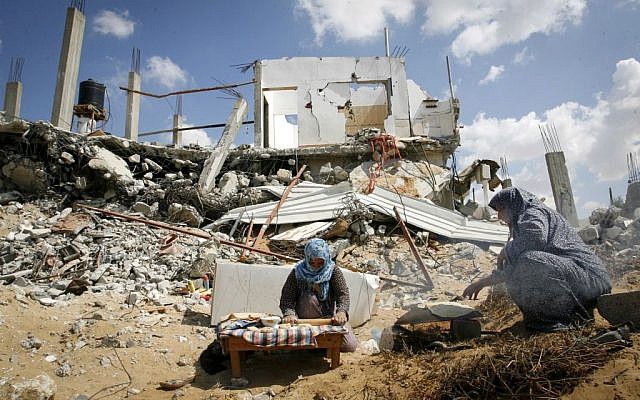 Palestinian women bake bread amid the rubble of their destroyed home in the town of Khan Younis, southern Gaza Strip, September 21, 2014. (Abed Rahim Khatib/Flash90)