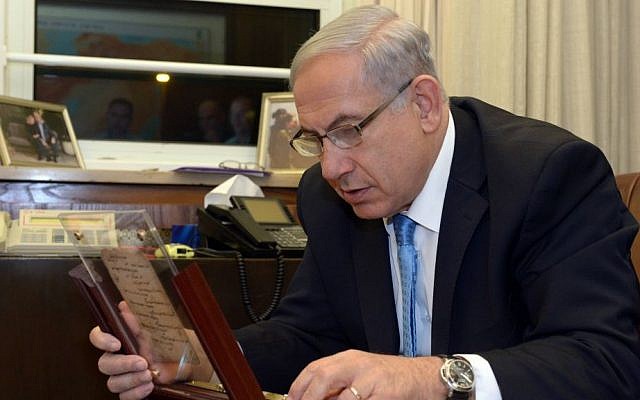 Prime Minister Benjamin Netanyahu examines what is said to be the world's oldest prayer book, now on display at the Bible Lands Museum. (photo credit: Chaim Tzach)