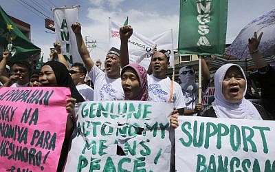 Filipino Muslims shout slogans during a rally near the Presidential Palace in support of the Bangsamoro Basic Law draft that was formally submitted by Philippine President Benigno Aquino III to both houses of Congress Wednesday, Sept. 10, 2014 in Manila, Philippines. (photo credit: AP Photo/Bullit Marquez)