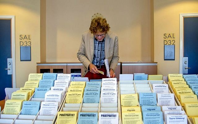 A man chooses among the ballot papers at a polling station in Goteborg during the Swedish general elections Sunday, Sept. 14, 2014. (photo credit: AP/Adam Ihse)