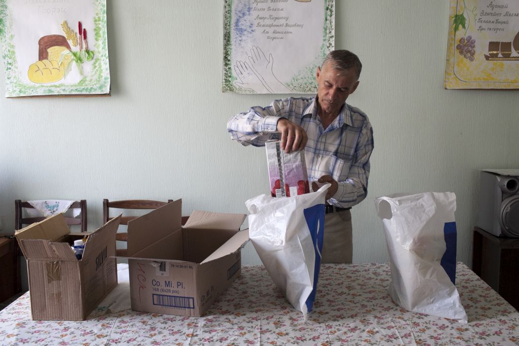JDC volunteer Vladimir packing bags of food intended for clients. Vladimir, who isn't Jewish, remained in Slavyansk helping JDC clients throughout the fighting. He delivered food to clients in small bags to reduce detectability and possible confiscation. (JDC, August 2014)