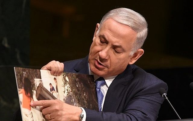 Prime Minister Benjamin Netanyahu holds up a photo of an alleged Hamas rocket near children as he addresses the 69th session of the United Nations General Assembly at the UN in New York, September 29, 2014. (photo credit: AFP/Don Emmert)