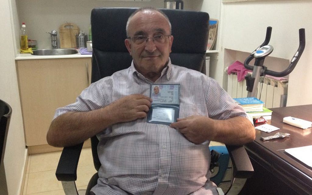 Yaakov Weksler-Waszkinel shows off his new Israeli identity card at his home in Jerusalem. (photo credit: Renee Ghert-Zand/The Times of Israel)