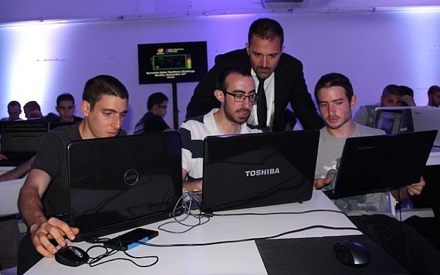 Antonio Forzieri (standing) checks out the work of one of the Israeli teams in the Cyber Challenge contest (Photo credit: Courtesy)