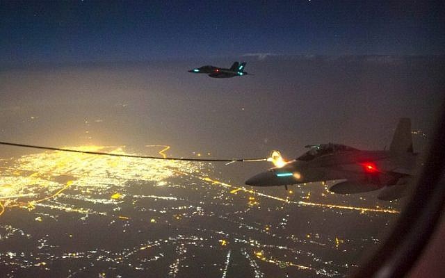 A handout photo taken October 5, 2014 and obtained on October 9 shows two Royal Australian Air Force (RAAF) F/A-18F Super Hornet aircraft refueling from a RAAF KC-30A Multi Role Tanker Transport aircraft above a city in Iraq. (AFP/Australian Defense/Sergeant Hamish Paterson)