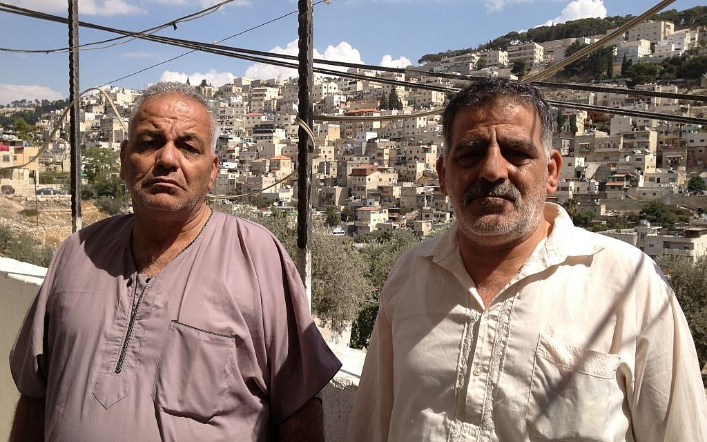 Elias Karaki (left) and his brother stand next to the house Nabil Karaki sold three months ago in Silwan, October 2, 2014. (photo credit: Elhanan Miller/Times of Israel)