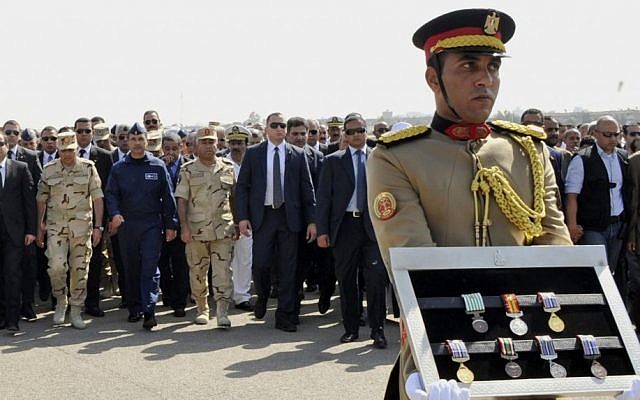 In this photo provided by Egypt's state news agency MENA, Egyptian President Abdel-Fattah el-Sissi, far left, and other officials follow a soldier carrying medals of troops killed in Friday's assault in the Sinai Peninsula, during a military funeral in Cairo, Egypt, Saturday, Oct. 25, 2014 [photo credit: AP/MENA)