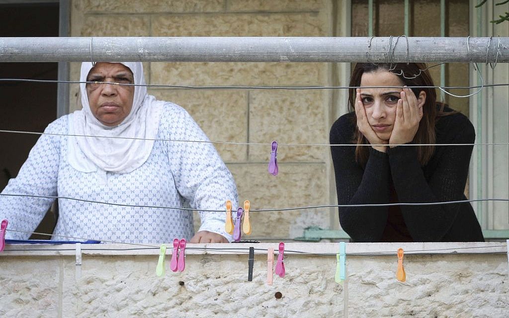 Palestinian women in Silwan watch as Jews enter homes purchased by Elad in the neighborhood, September 30, 2014 (photo credit: Sliman Khader/Fash90)