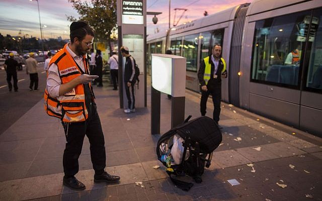 Police and rescue personnel near a baby stroller at the scene of a terror attack at a Jerusalem light rail station, by Ammunition Hill. October 22, 2014. (Photo credit: Yonatan Sindel/Flash90)