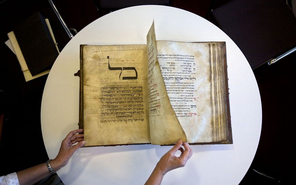 A library official shows a 13th-century German prayer book containing the earliest evidence of the Yiddish language, at Israel’s National Library in Jerusalem, October 5, 2014. (AP/Sebastian Scheiner)
