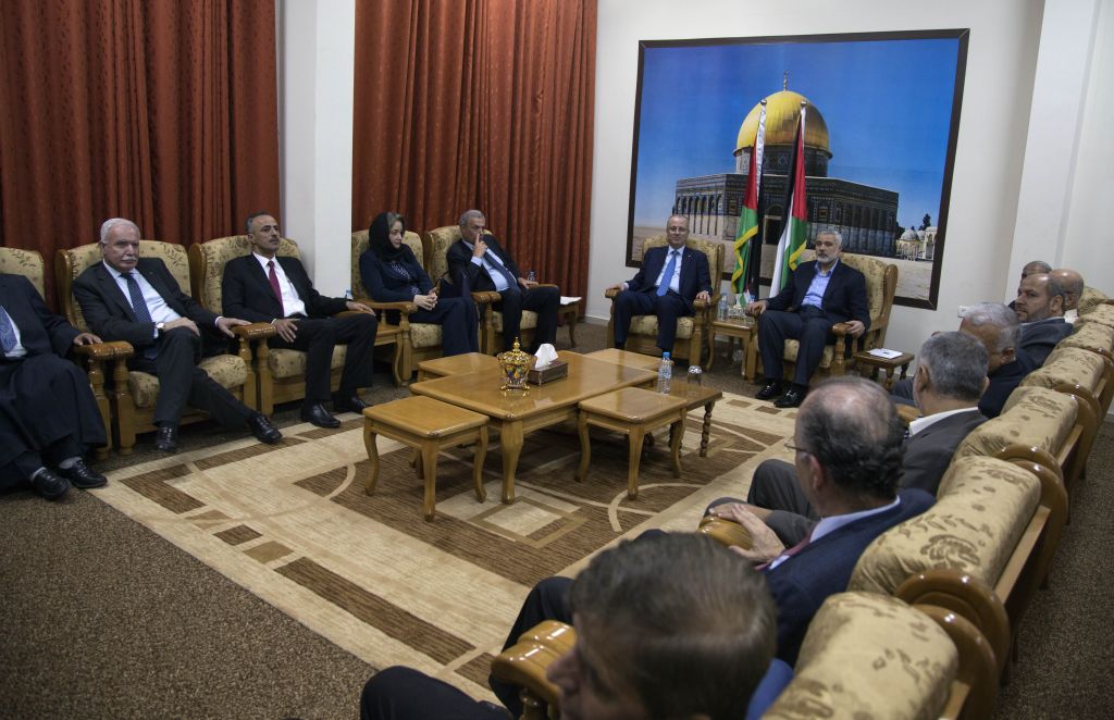 Palestinian Authority Prime Minister Rami Hamdallah and the ministers of the the new Palestinian unity government meet with top Hamas leader in Gaza, Ismail Hamiyeh, in Gaza City, Thursday, Oct. 9, 2014. Members of the new Palestinian unity government assembled in Gaza on Thursday for their first Cabinet session in the war-battered territory, a largely symbolic meeting meant to mark the end of absolute Hamas control of the coastal strip. (photo credit: AP Photo/Khalil Hamra)