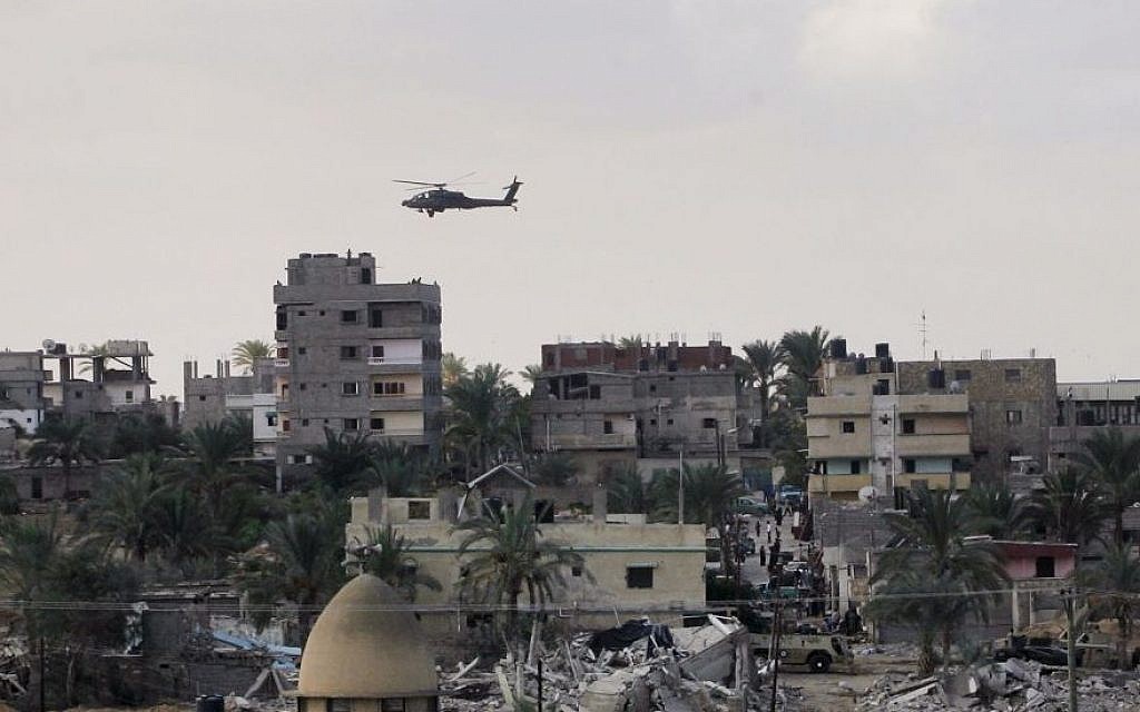 An Egyptian helicopter hovers over houses destroyed by the Egyptian army on the Egyptian side on the border town of Rafah, Wednesday, Oct. 29, 2014. (Photo credit: AP/Eyad Baba)