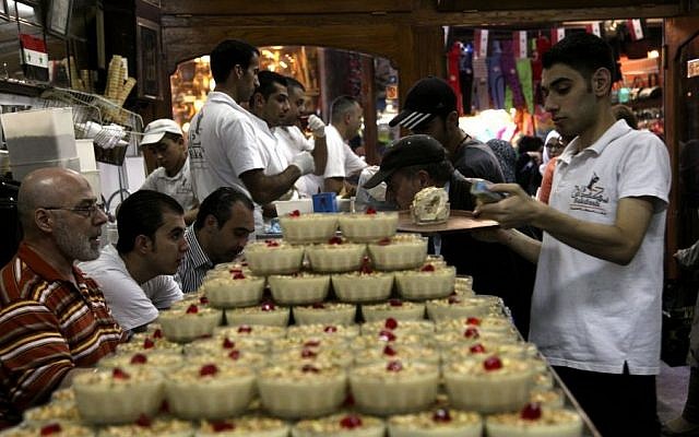Waiters prepare deserts in Bekdash, an ice-cream shop considered to make the finest Levantine gelato in the ancient bazaar known as the Hamdiyeh souq, in Damascus, Syria, Monday, Oct. 27, 2014. (photo credit: AP/Diaa Hadid)