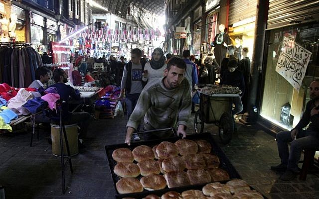 A bread seller pushes his wares through the ancient bazaar known as the Hamidiyeh souq in Damascus, Syria, Monday, Oct. 27, 2014. (photo credit: AP/Diaa Hadid)