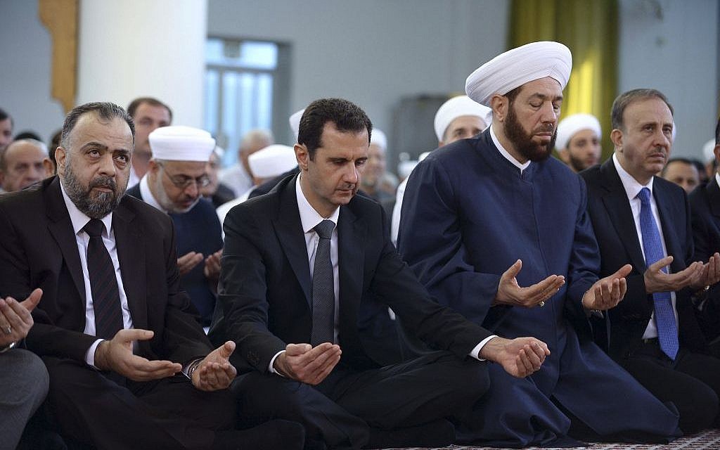 Syrian President Bashar Assad, center, prays during Eid al-Adha prayers at a mosque in Damascus, Syria, October 4, 2014. (photo credit: AP/SANA)