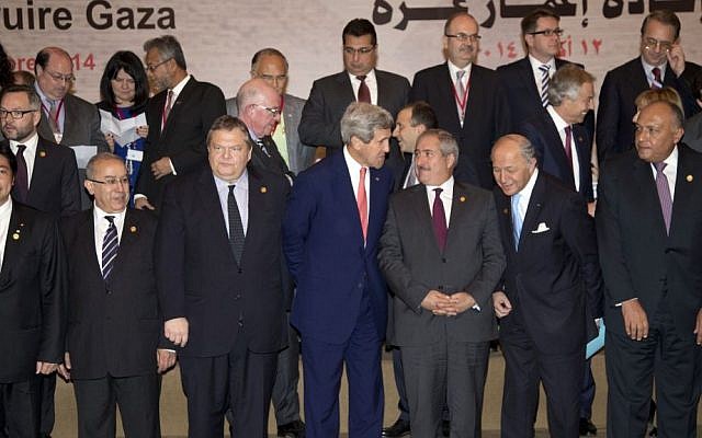 US Secretary of State John Kerry, front and center, talks with Jordanian Foreign Minister Nasser Judeh, to his right, as they gather for a group photo with other Gaza Donor Conference attendees in Cairo, Egypt, Sunday, October 12, 2014, where Kerry announced $212 million in US assistance. (photo credit: AP Photo/Carolyn Kaster, Pool)