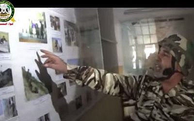 A Free Syrian Army fighter points out photographs of Russian officers visiting a secret intelligence facility on the Syrian Golan Heights (screen capture: YouTube)